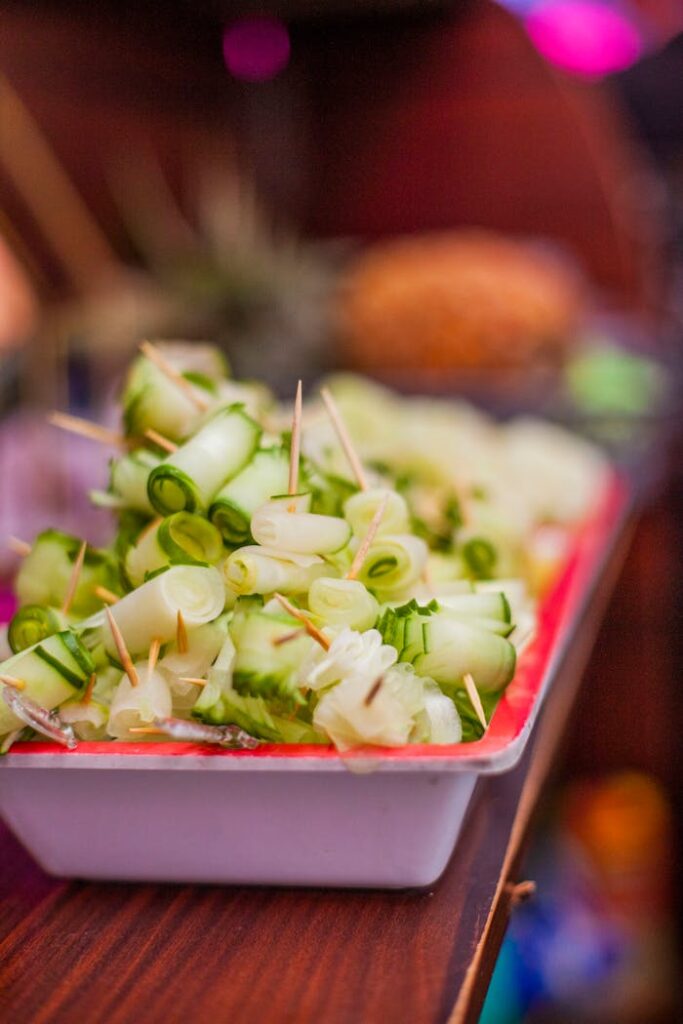 Close-up of rolled cucumber appetizers with toothpicks on a wooden table, perfect for healthy snacking.